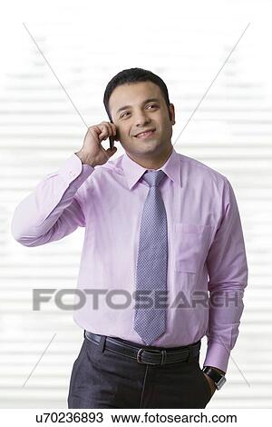 Stock Image - Business executive talking on a mobile phone . Fotosearch