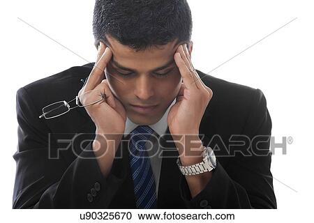 Stock Image - Business man suffering from severe headache . Fotosearch