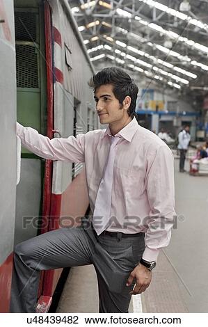 Stock Image - Businessman boarding a train . Fotosearch