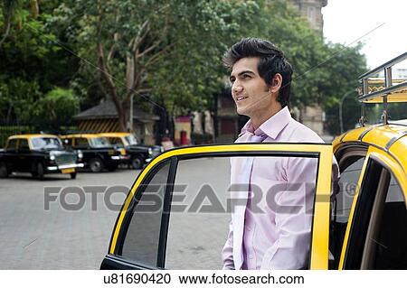 Businessman getting out of a taxi View Large Photo Image Stock Image - Businessman getting out of a taxi . Fotosearch