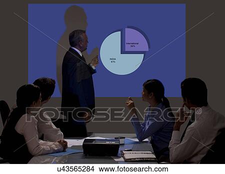 Businessman giving presentation on projection screen View Large Photo Image Picture - Businessman giving presentation on projection screen . Fotosearch