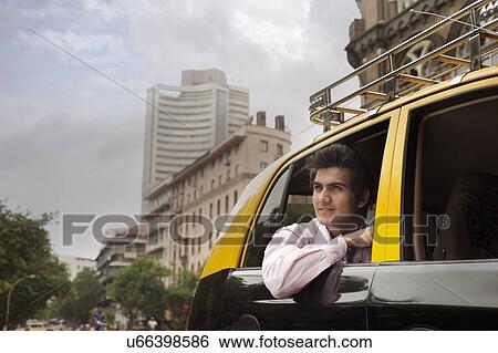 Businessman looking out of a taxi View Large Photo Image Stock Photograph - Businessman looking out of a taxi . Fotosearch