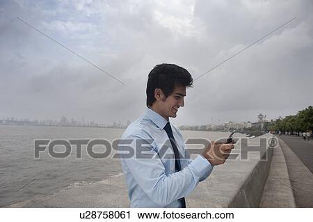 Businessman reading an sms View Large Photo Image Stock Image - Businessman reading an sms . Fotosearch