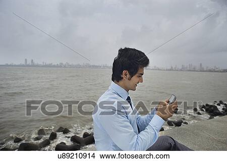 Picture - Businessman sending an sms . Fotosearch
