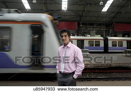 Businessman standing at a train station View Large Photo Image Stock Image - Businessman standing at a train station . Fotosearch