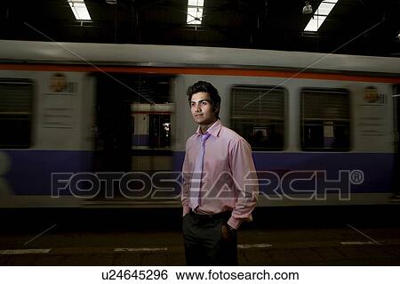 Stock Photograph - Businessman standing at a train station . Fotosearch