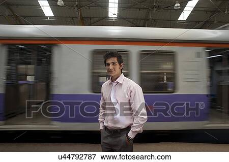 Stock Photo - Businessman standing next to a train compartment . Fotosearch