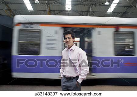 Businessman standing next to a train compartment View Large Photo Image Stock Photo - Businessman standing next to a train compartment . Fotosearch
