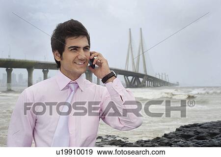 Stock Photo - Businessman talking on a mobile phone . Fotosearch