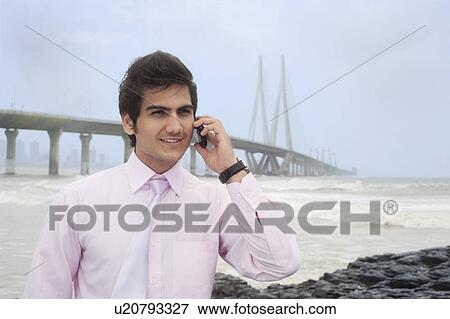 Stock Photo - Businessman talking on a mobile phone . Fotosearch