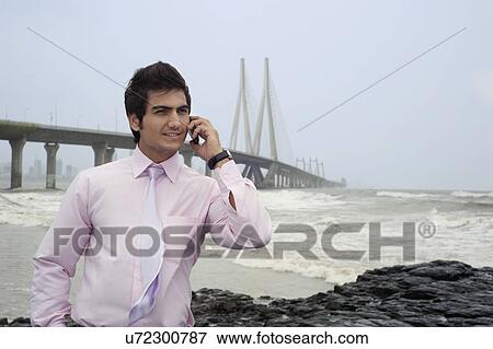 Stock Photo - Businessman talking on a mobile phone . Fotosearch