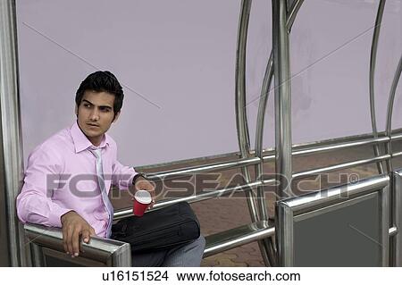 Businessman waiting at a bus stop View Large Photo Image Picture - Businessman waiting at a bus stop . Fotosearch