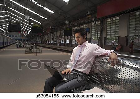 Businessman with a laptop at a train station View Large Photo Image Stock Photography - Businessman with a laptop at a train station . Fotosearch