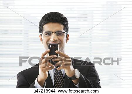 Businessman with a mobile phone View Large Photo Image Picture - Businessman with a mobile phone . Fotosearch