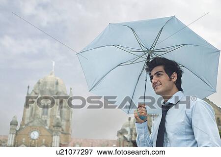 Businessman with an umbrella View Large Photo Image Stock Photo - Businessman with an umbrella . Fotosearch