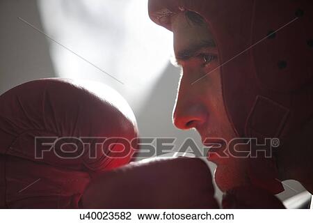 Stock Image - Businessman with boxing gloves in boxing stance . Fotosearch