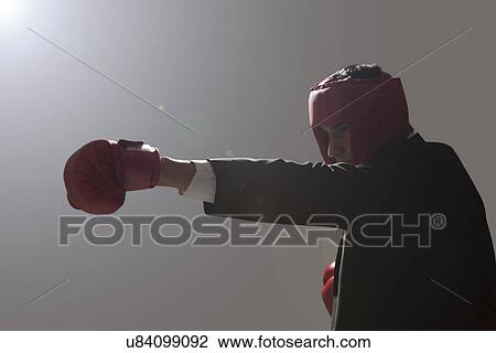 Businessman with boxing gloves punching View Large Photo Image Stock Image - Businessman with boxing gloves punching . Fotosearch
