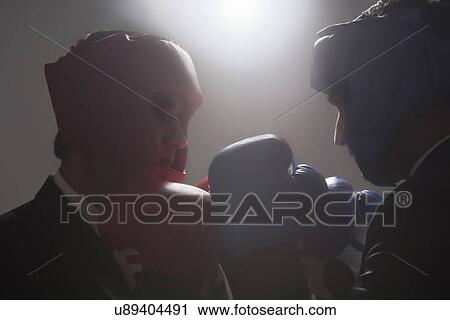 Stock Image - Businessmen with boxing gloves facing each other . Fotosearch