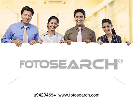 Businesspeople holding a placard View Large Photo Image Picture - Businesspeople holding a placard . Fotosearch