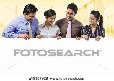 Businesspeople holding a placard View Large Photo Image Stock Photo - Businesspeople holding a placard . Fotosearch