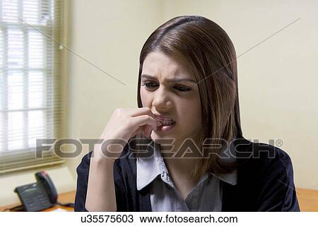 Stock Image - Businesswoman biting her nails . Fotosearch