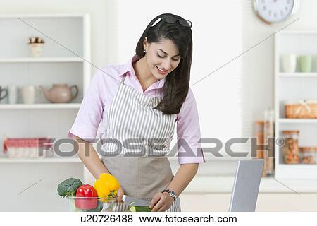 Businesswoman cutting vegetables in kitchen View Large Photo Image Stock Photo - Businesswoman cutting vegetables in kitchen. Fotosearch