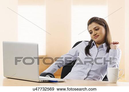 Businesswoman feeling lazy at work View Large Photo Image Stock Photo - Businesswoman feeling lazy at work . Fotosearch