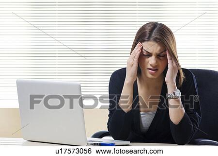 Stock Photograph - Businesswoman getting a headache at work . Fotosearch