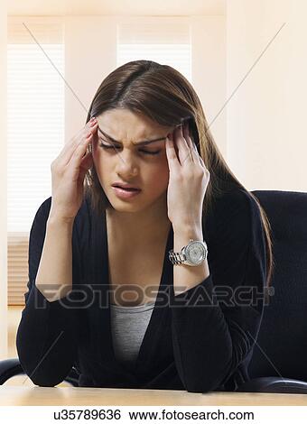 Businesswoman getting a headache View Large Photo Image Stock Photograph - Businesswoman getting a headache . Fotosearch