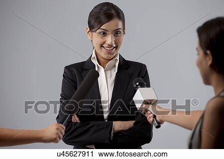 Businesswoman giving interview against colored background View Large Photo Image Stock Image - Businesswoman giving interview against colored background . Fotosearch