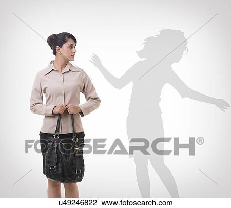 Businesswoman looking at shadow dancing over gray background View Large Photo Image Stock Image - Businesswoman looking at shadow dancing over gray background. Fotosearch
