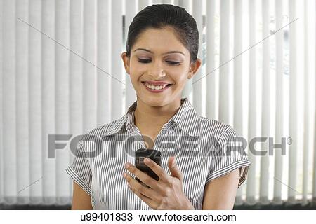 Businesswoman reading a message on a mobile phone View Large Photo Image Stock Image - Businesswoman reading a message on a mobile phone . Fotosearch