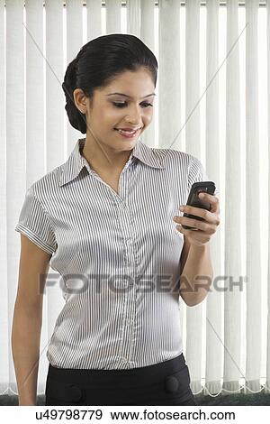 Stock Photo - Businesswoman reading a message on a mobile phone . Fotosearch