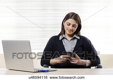 Businesswoman reading a message on a mobile phone View Large Photo Image Stock Photograph - Businesswoman reading a message on a mobile phone . Fotosearch