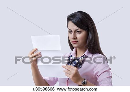 Businesswoman reading document over gray background View Large Photo Image Stock Photograph - Businesswoman reading document over gray background. Fotosearch