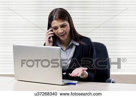 Businesswoman talking on a mobile phone View Large Photo Image Stock Image - Businesswoman talking on a mobile phone . Fotosearch