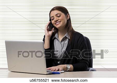 Stock Image - Businesswoman talking on a mobile phone . Fotosearch