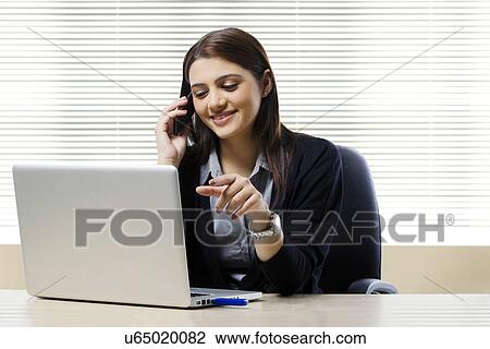 Stock Image - Businesswoman talking on a mobile phone . Fotosearch