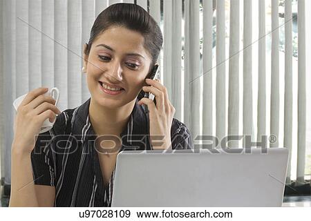 Stock Photo - Businesswoman talking on a mobile phone . Fotosearch