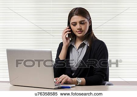 Businesswoman talking on a mobile phone View Large Photo Image Stock Photography - Businesswoman talking on a mobile phone . Fotosearch