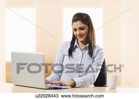 Businesswoman working on a laptop View Large Photo Image Stock Image - Businesswoman working on a laptop . Fotosearch