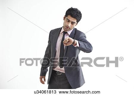 Busy businessman checking time over white background View Large Photo Image Stock Image - Busy businessman checking time over white background . Fotosearch