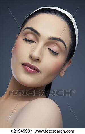 Calm young woman with eyes closed over colored background View Large Photo Image Stock Photo - Calm young woman with eyes closed over colored background . Fotosearch
