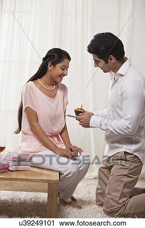 Caring young man giving cake to woman on birthday View Large Photo Image Stock Image - Caring young man giving cake to woman on birthday . Fotosearch