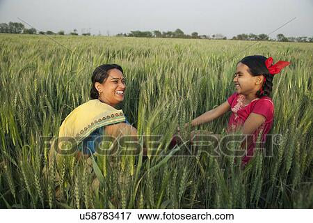 Cheerful mother and daughter playing in the wheat field View Large Photo Image Stock Photo - Cheerful mother and daughter playing in the wheat field . Fotosearch