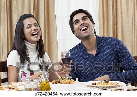 Cheerful young couple enjoying the meal at restaurant View Large Photo Image Picture - Cheerful young couple enjoying the meal at restaurant . Fotosearch
