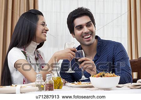 Cheerful young couple enjoying the meal at restaurant View Large Photo Image Stock Image - Cheerful young couple enjoying the meal at restaurant . Fotosearch