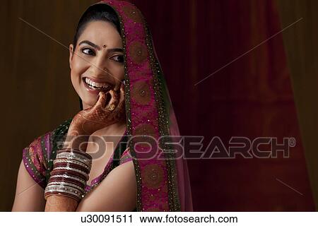 Cheerful young Indian bride looking away View Large Photo Image Stock Image - Cheerful young Indian bride looking away . Fotosearch