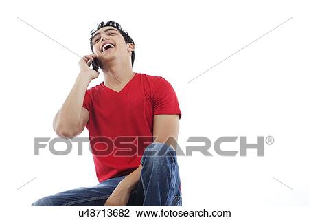 Cheerful young man laughing on the phone over white background View Large Photo Image Stock Image - Cheerful young man laughing on the phone over white background . Fotosearch