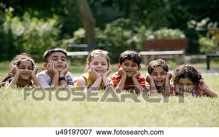 Stock Photo - Children lying on the grass . Fotosearch